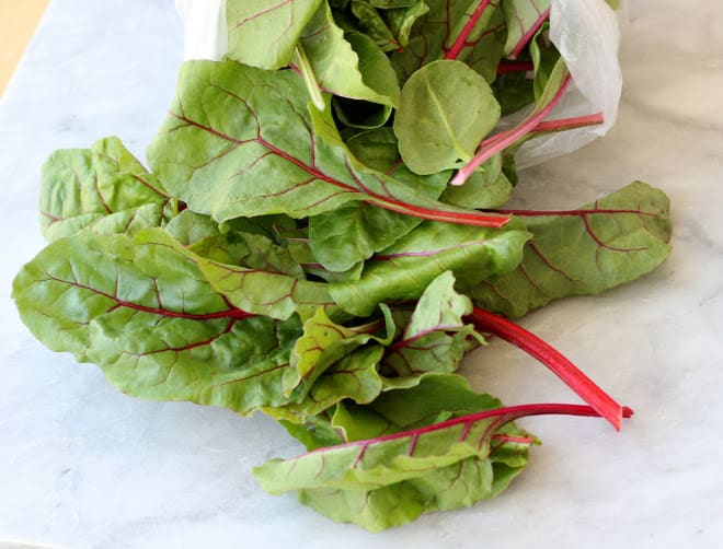 swiss chard leaves on marble background
