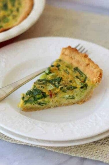 slice of quiche on white plate with fork
