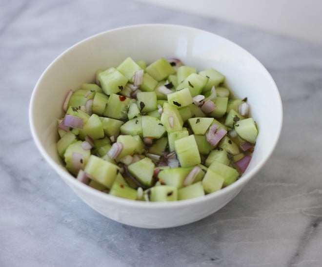 Bowl of chopped pickled cucumbers in a white bowl