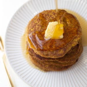 pumpkin oatmeal pancake on white plate with gold fork