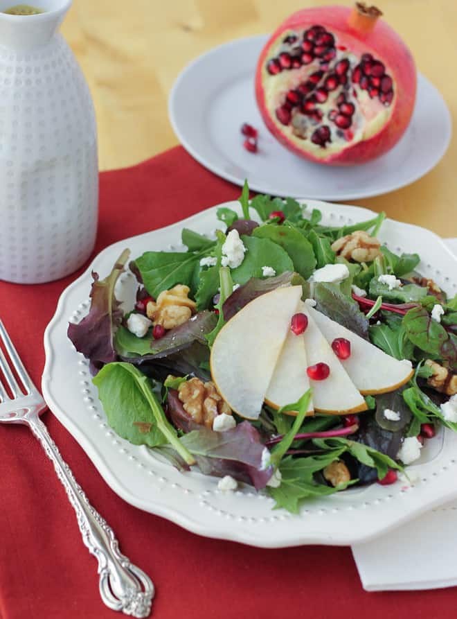 Salad on a white plate with a pomegranate 