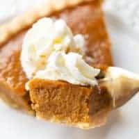 Slice of pumpkin pie with a piece on a fork