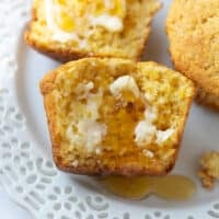 gluten free corn muffin on white plate with honey