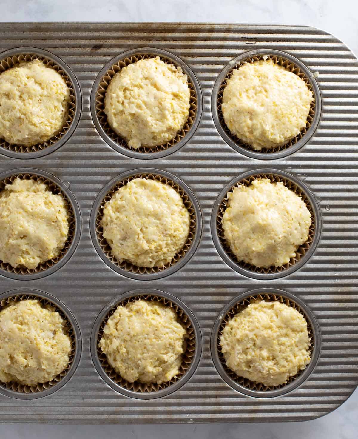 muffin batter scooped into muffin tin