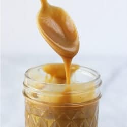 Spoon coming out of a jar of caramel