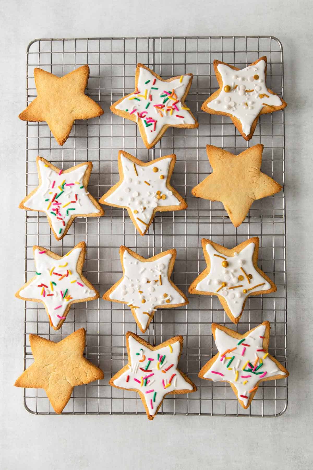 almond flour sugar cookies on baking sheet decorated with frosting and sprinkles