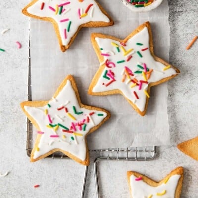 almond flour sugar cookies topped with white frosting and sprinkles