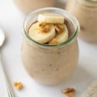 banana chia pudding in glass jar topped with banana slices and walnuts