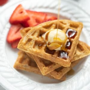 gluten free waffle on white plate with syrup