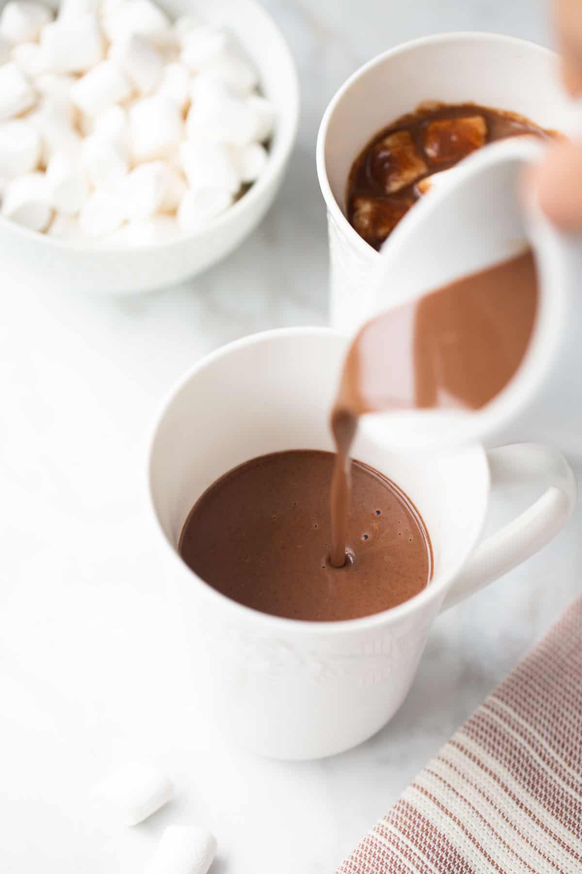 dairy-free almond milk hot chocolate being poured into a white mug