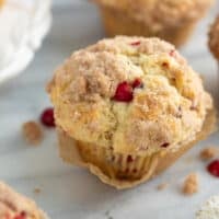 cranberry muffin on marble background with crumbs and white napkin