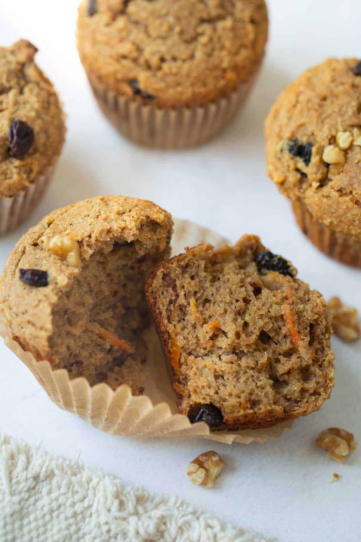 muffin cut in half with 3 muffins in background on white background