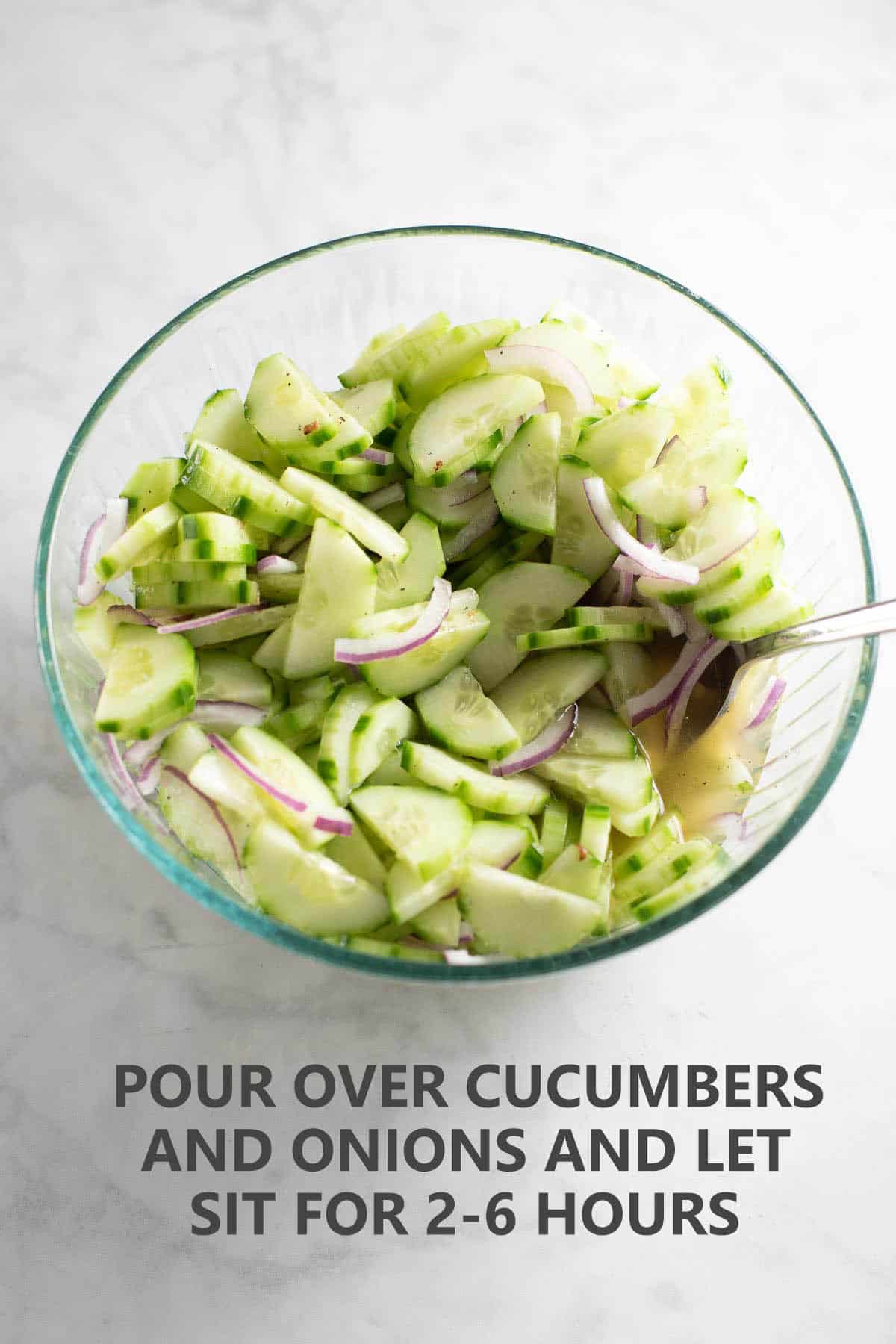 bowl of cucumbers and onions with apple cider dressing poured over