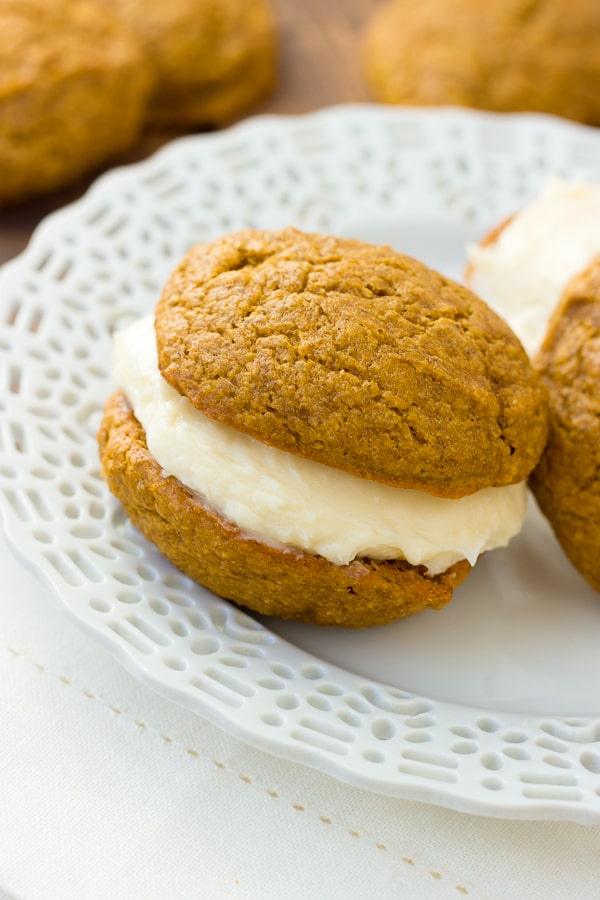 Gluten-Free Pumpkin Whoopie Pies! Two moist, spiced pumpkin cookies filled with thick cream cheese frosting. A fall favorite! (Dairy-Free Option)