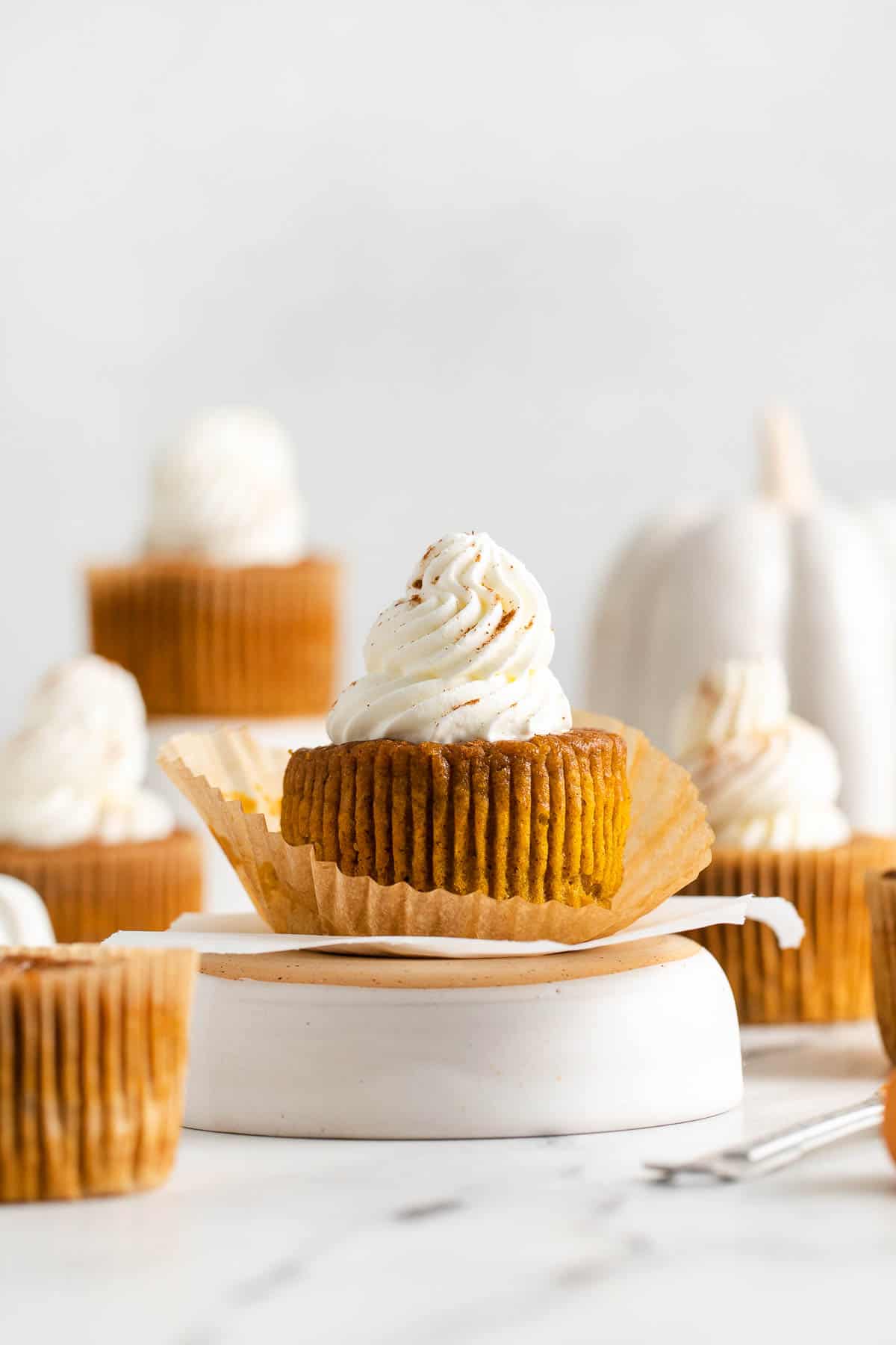 crustless pumpkin pie topped with whipped cream on white surface