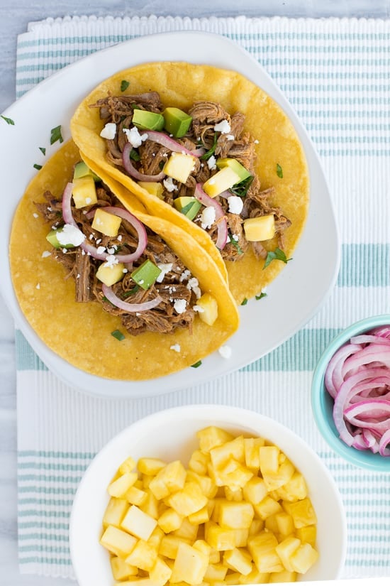 overhead shot of tacos on white plate with blue striped napkin