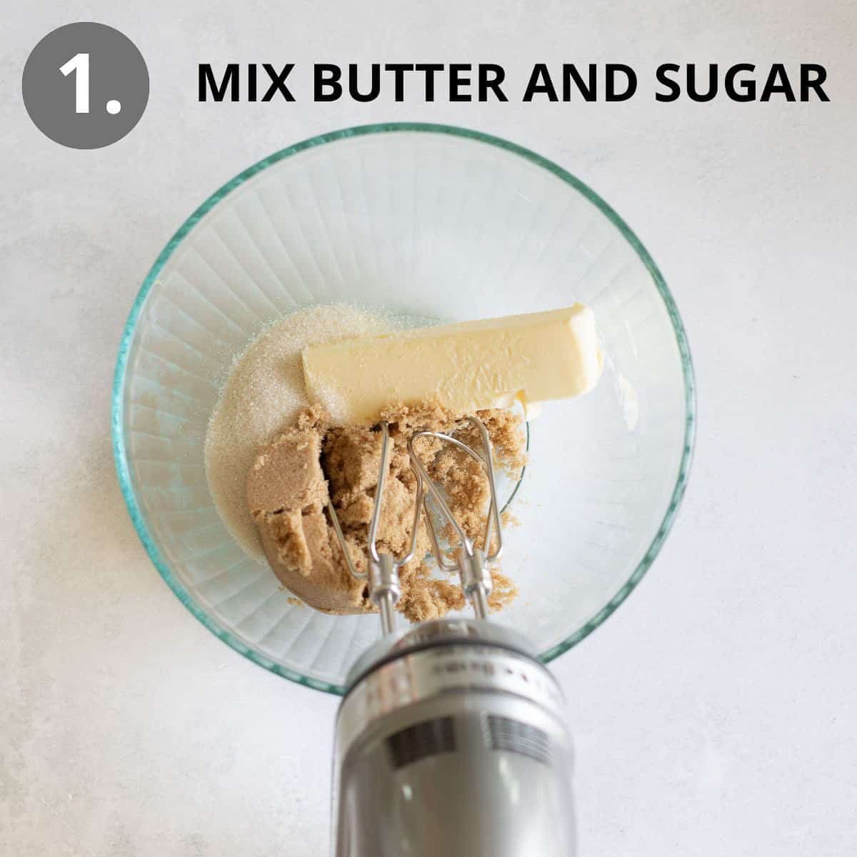 Butter and sugar in a glass bowl with a hand mixer over the top