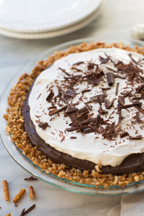 vegan chocolate pie in pie plate with coconut cream and chocolate shavings