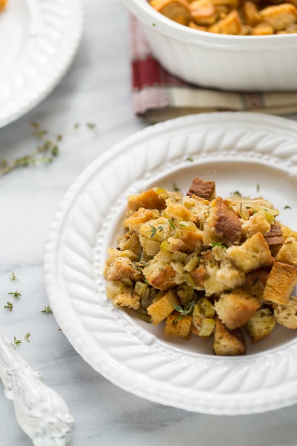 stuffing on white plate topped with thyme