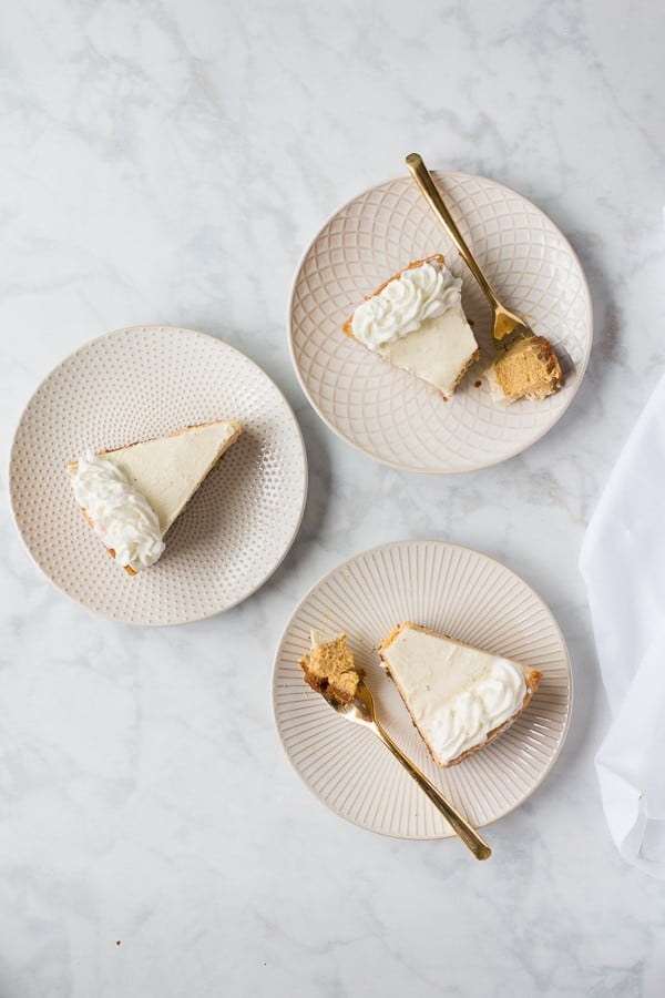 slices of pumpkin cheesecake with forks with marble background