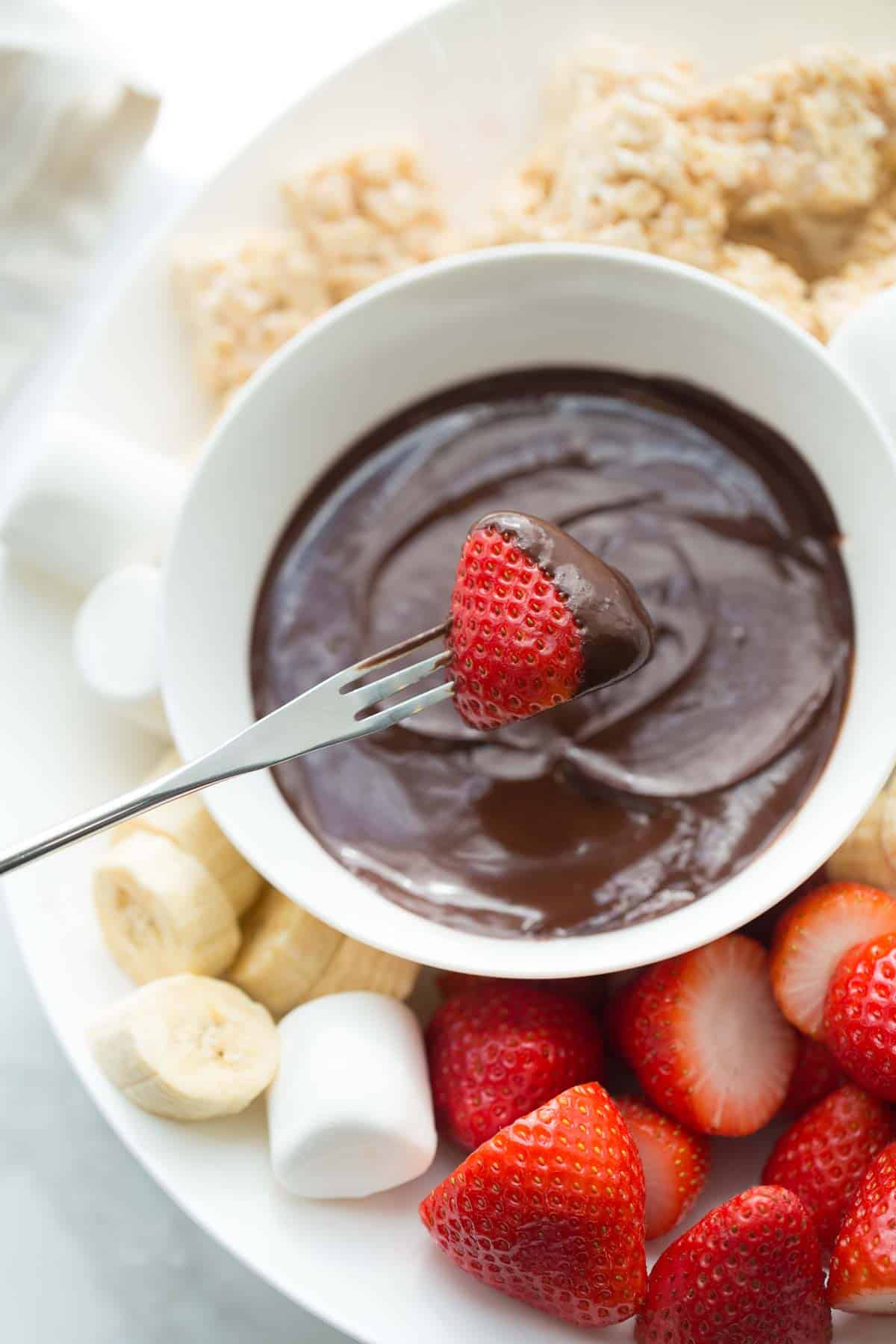 strawberry being dipped into chocolate fondue