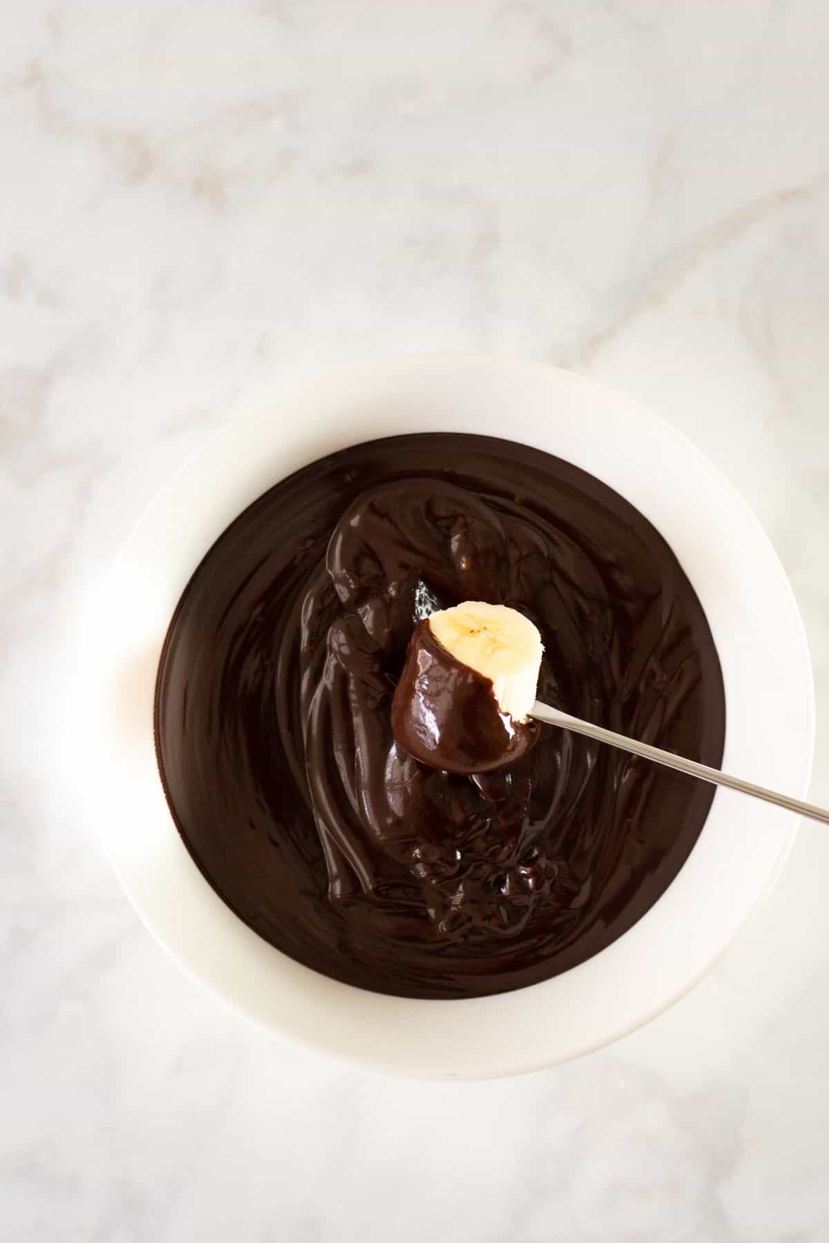 banana being dipped into chocolate fondue