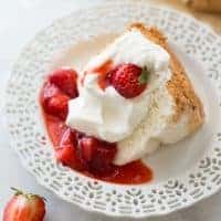 slice of gluten-free angel food cake on white plate with strawberries