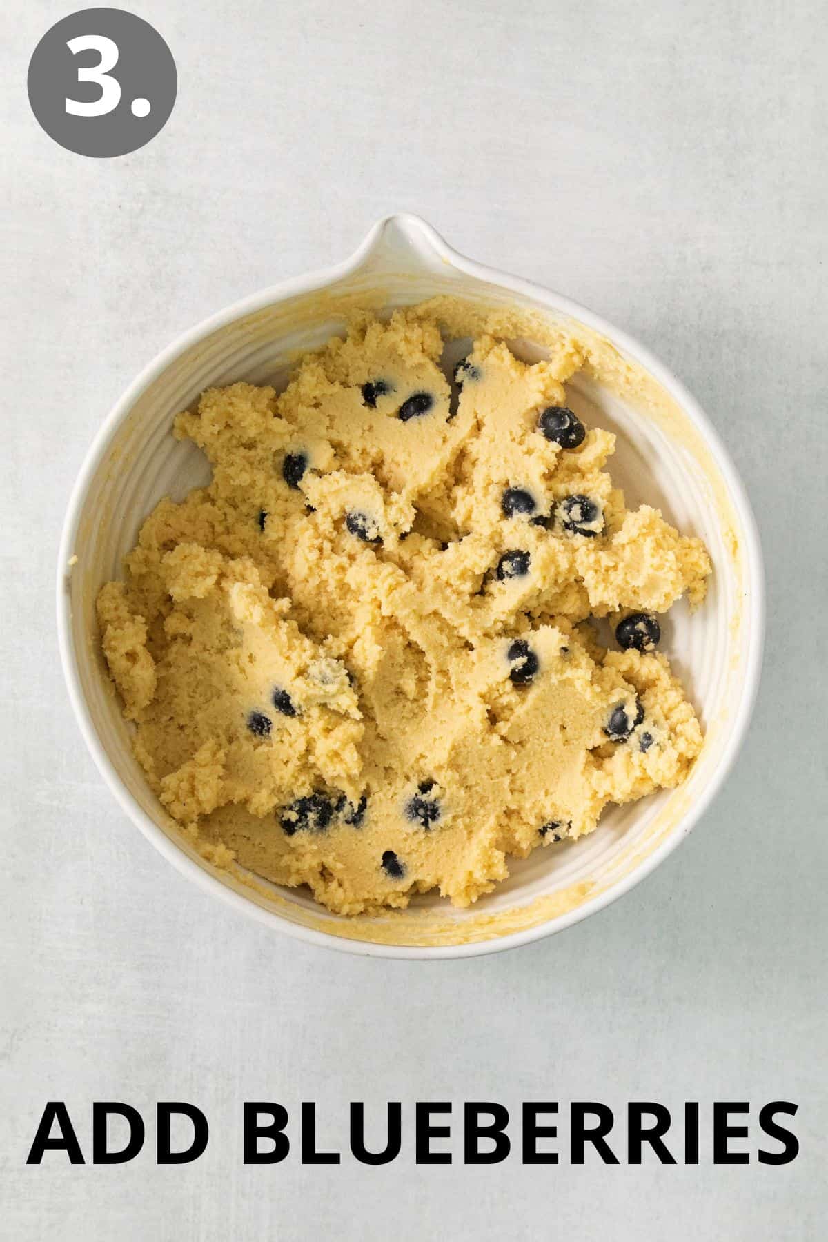 Blueberries added to the muffin batter in a bowl