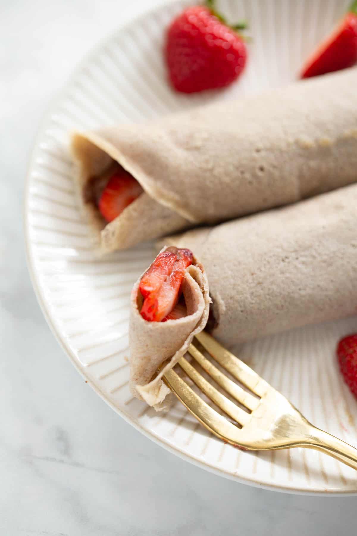 close up shot of buckwheat crepes with bite in fork