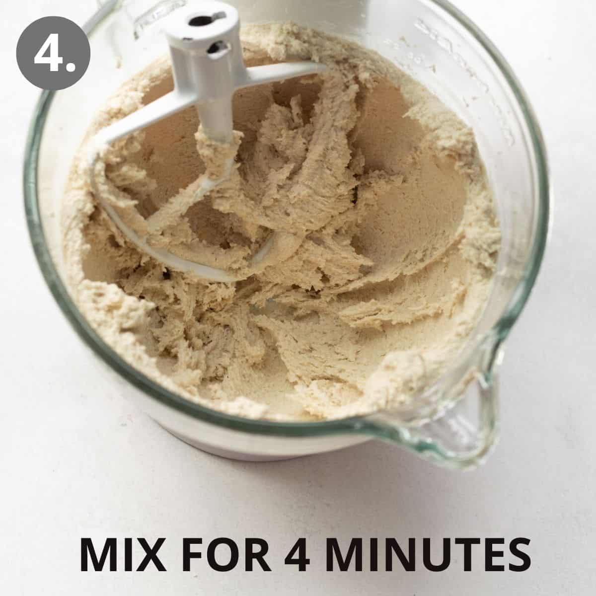 A standing mixer with the wet and dry ingredients being mixed together