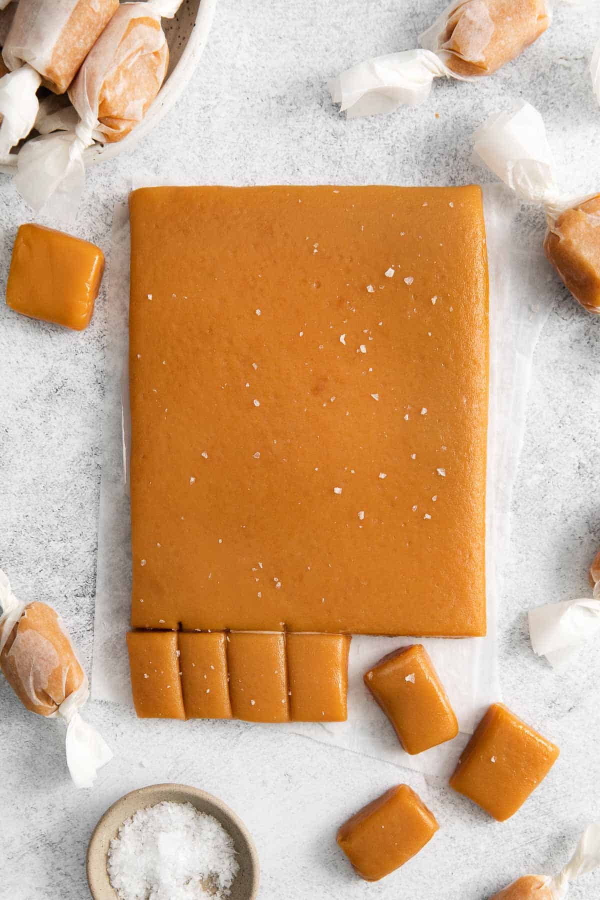 A slab of caramel being cut into individual portions