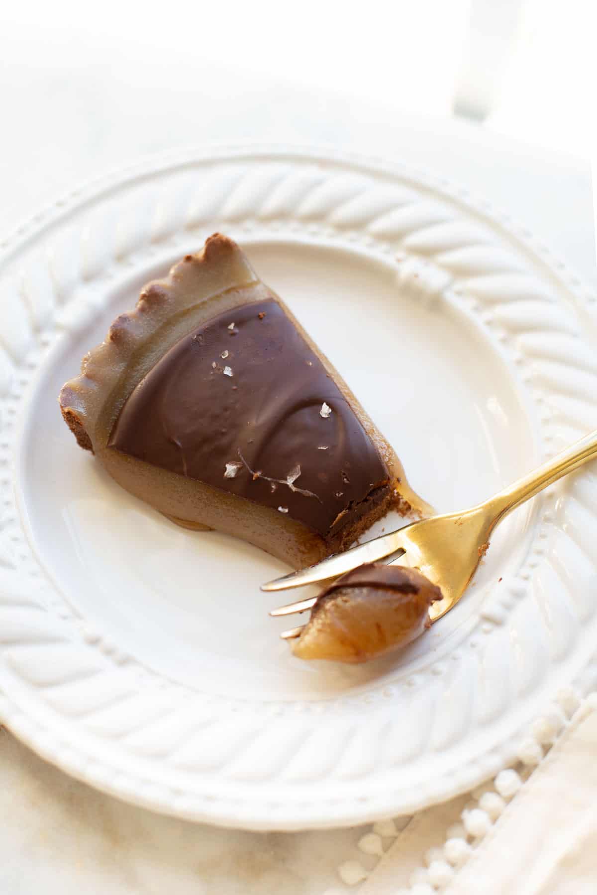 slice of chocolate caramel tart with bite from fork