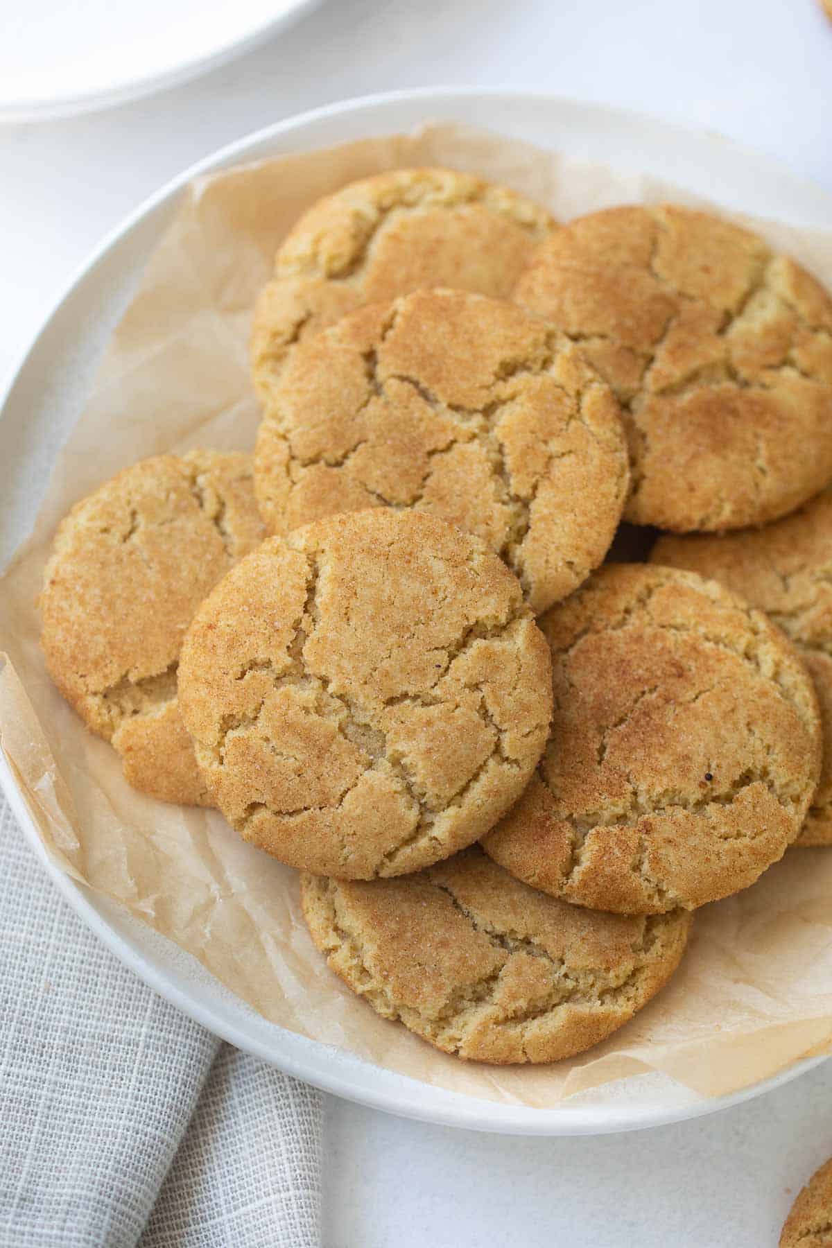gluten-free snickerdoodles on white plate with brown parchment paper
