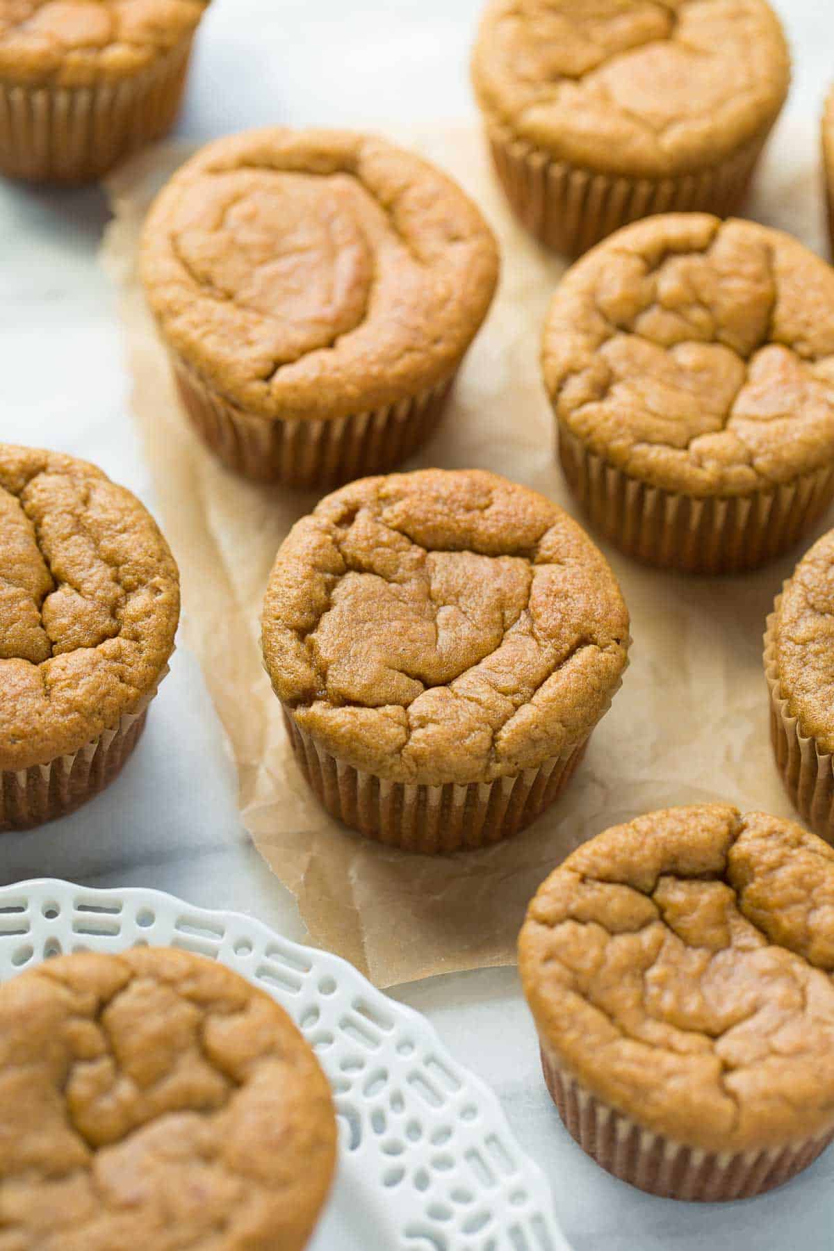 coconut flour banana muffins on white plate with marble background and brown parchment