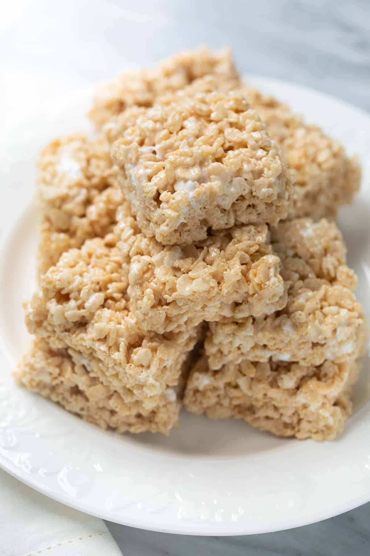 gluten free rice krispies treats stacked on a white plate
