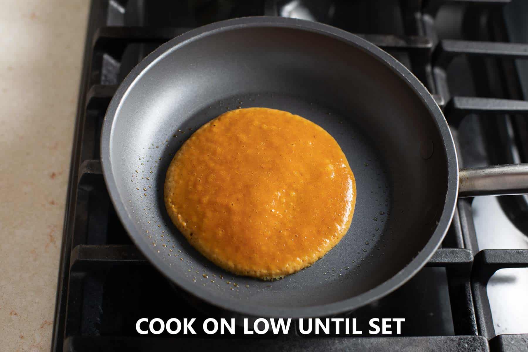 pancake batter poured into nonstick pan cooking