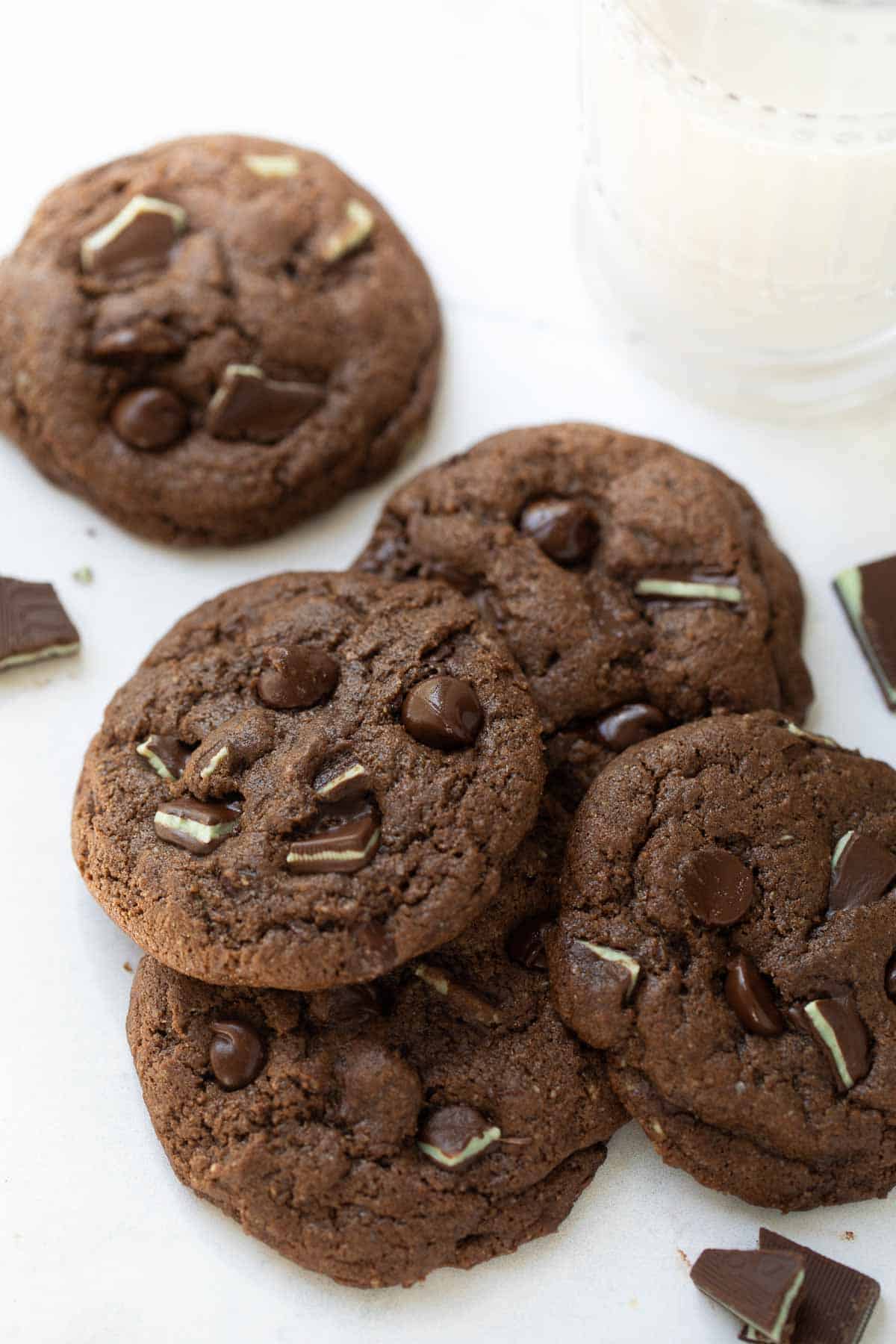 close up shot of gluten free chocolate mint cookies on white background with milk