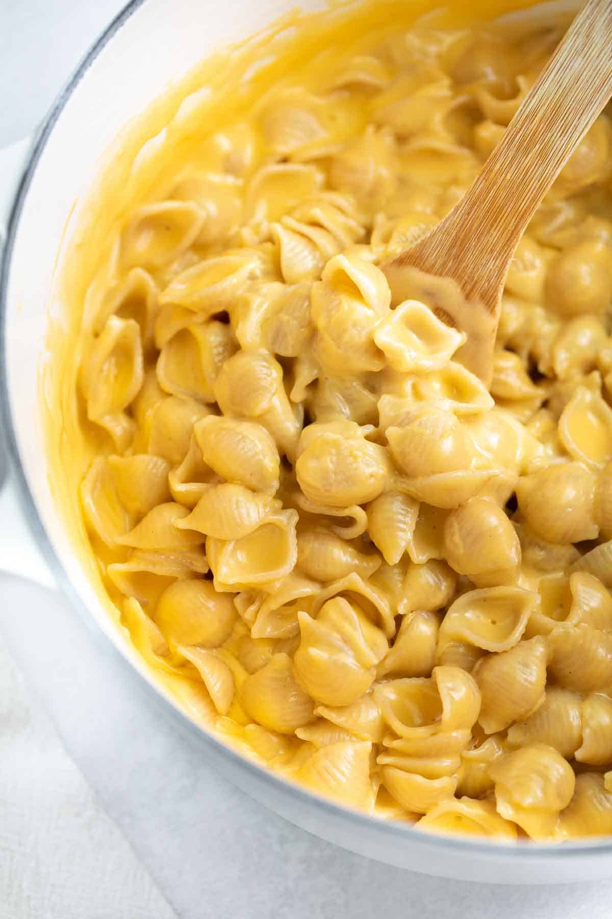 close up of gluten free mac and cheese in white pot with spoon 