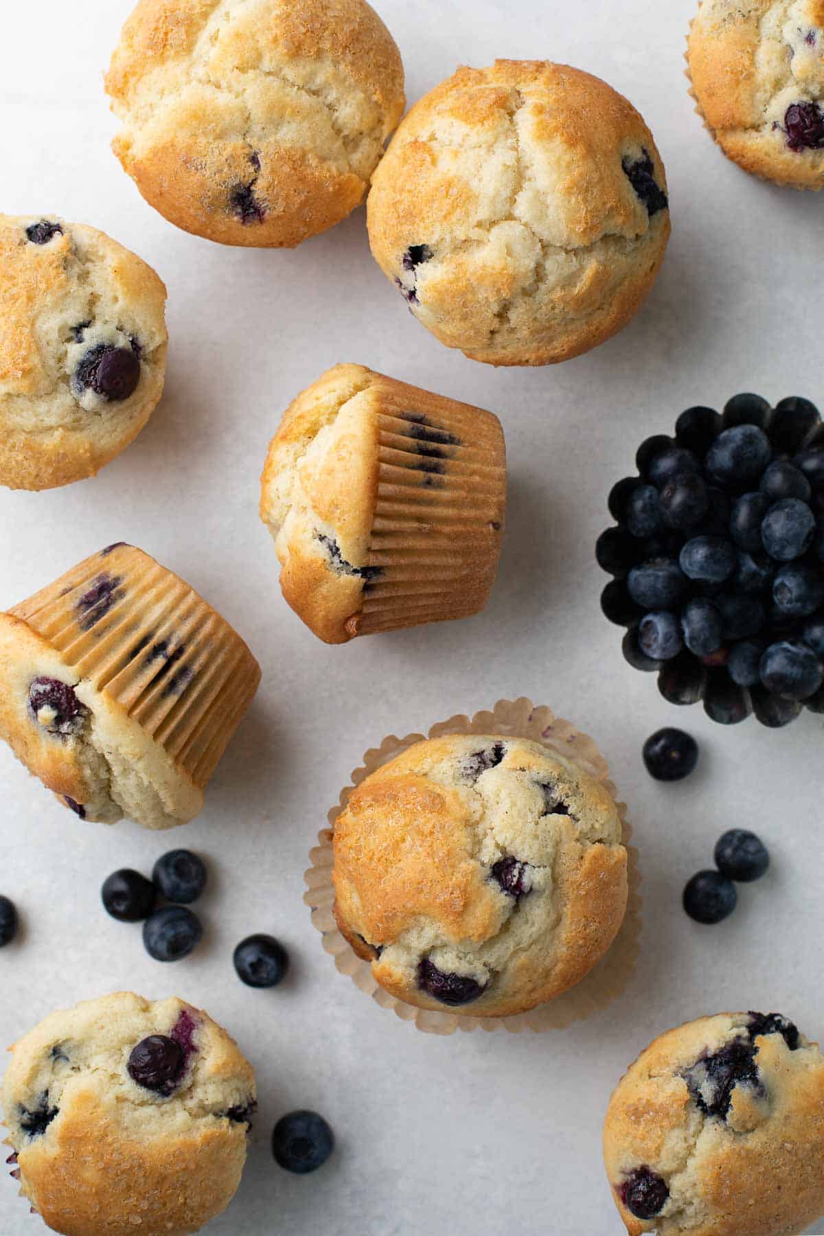 overhead shot of blueberry muffins on gray background topped with raw sugar