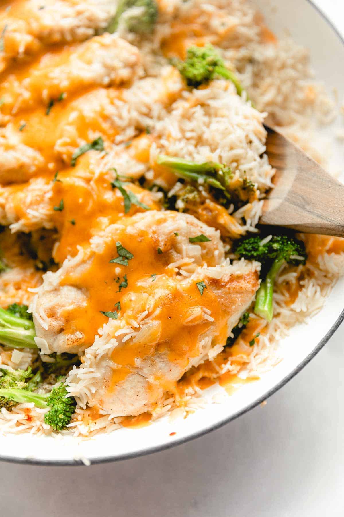 close up shot of gluten free chicken and rice in white dish with broccoli