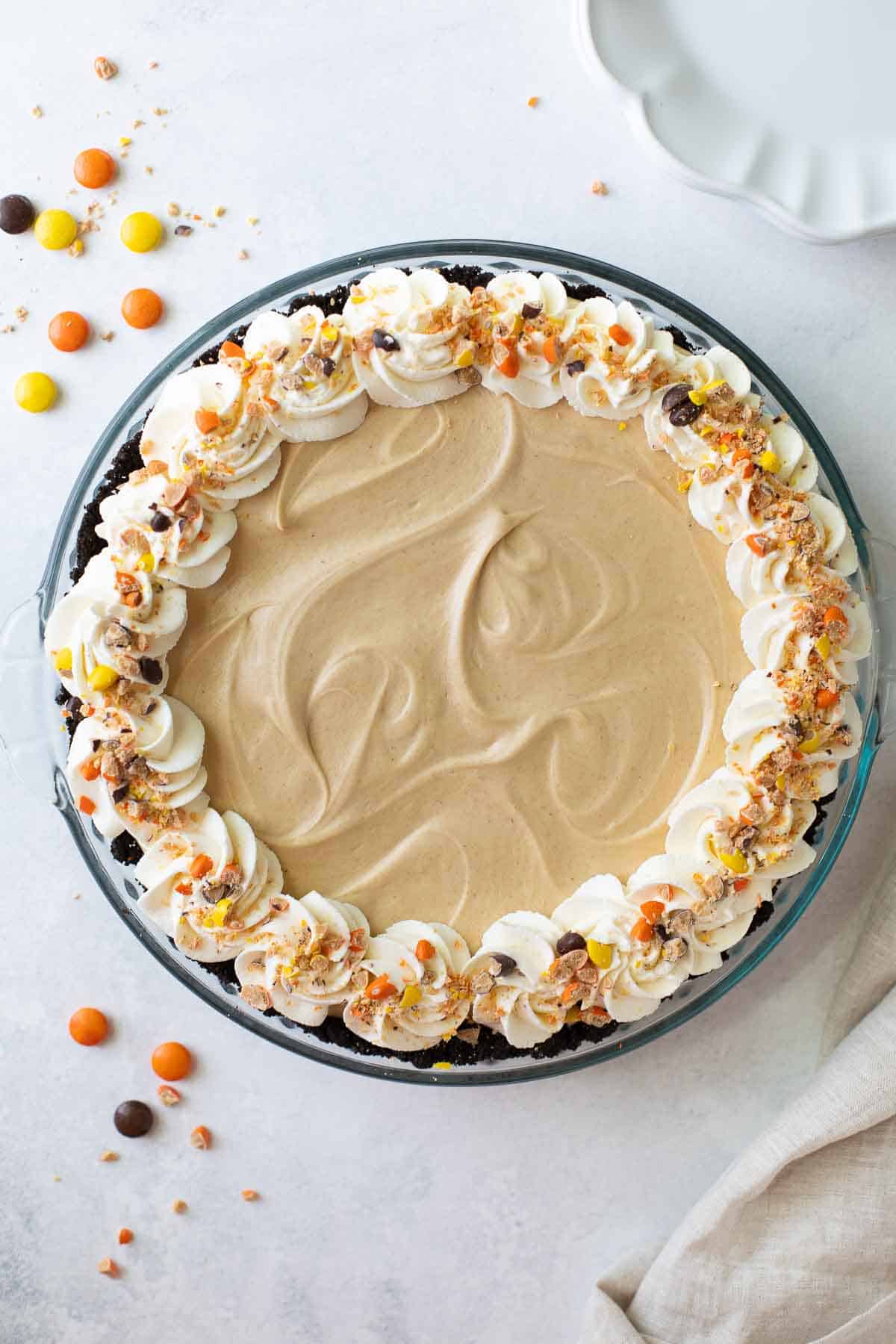 overhead of penaut butter pie with frosting and peanut m&M candies