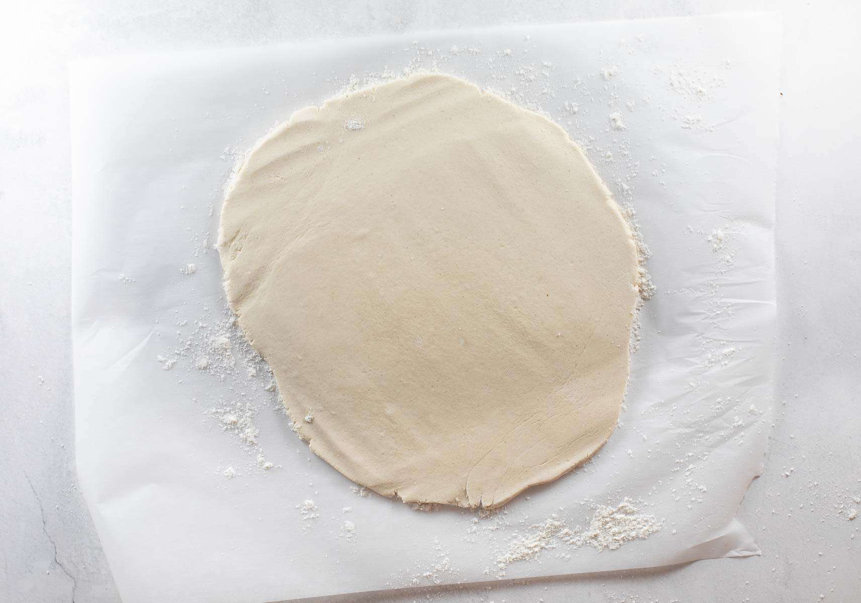 dough rolled out on parchment paper