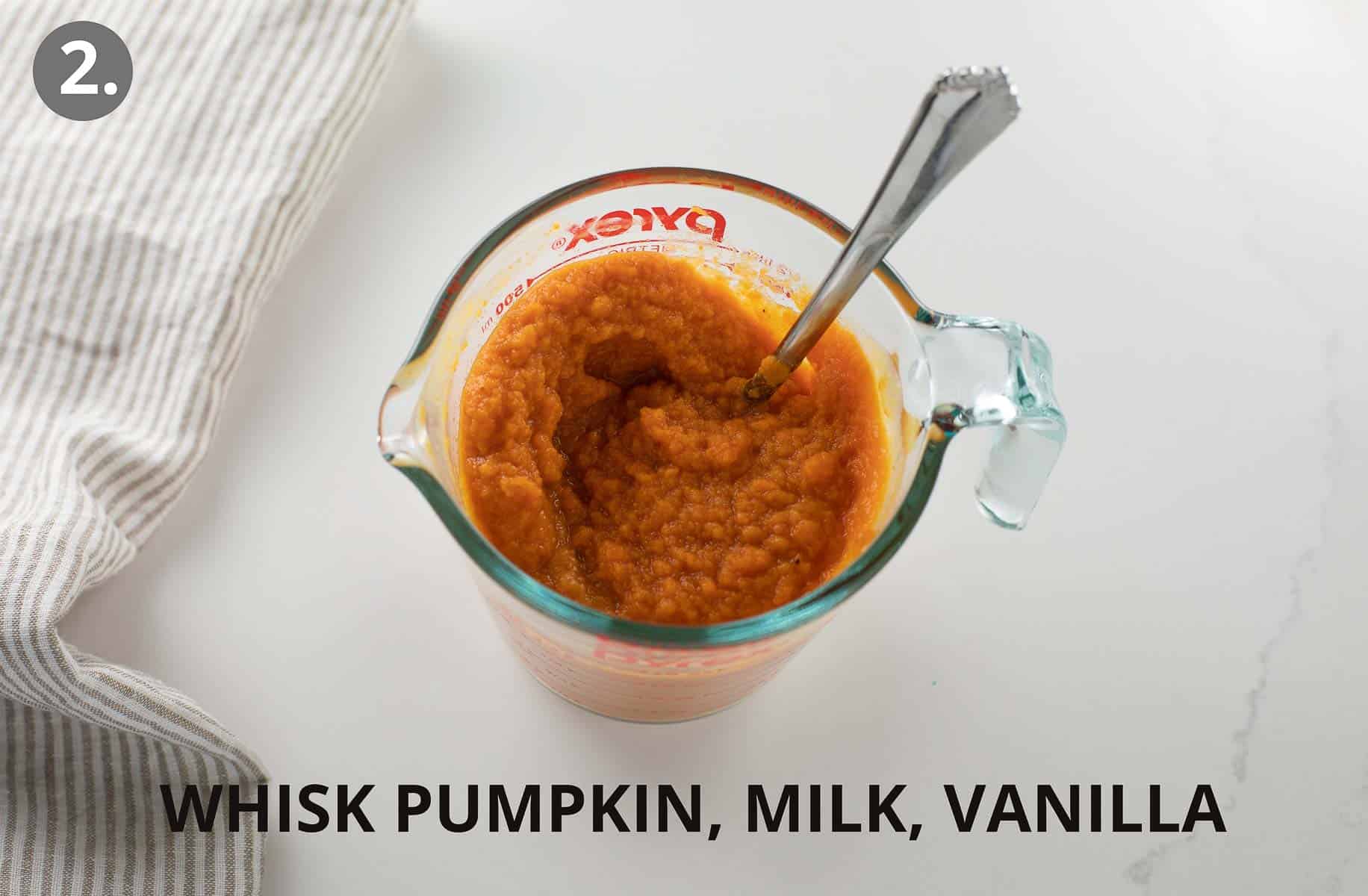pumpkin and wet ingredients mixed together in glass measuring cup