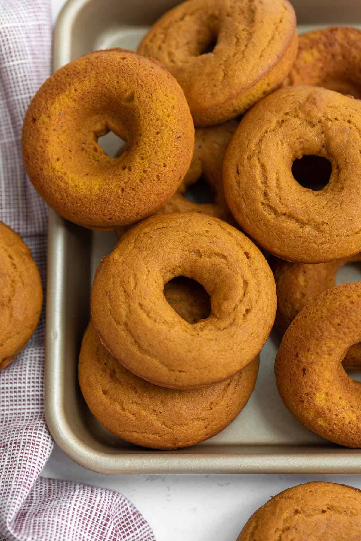 baked pumpkin donuts on baking sheet before being glazed