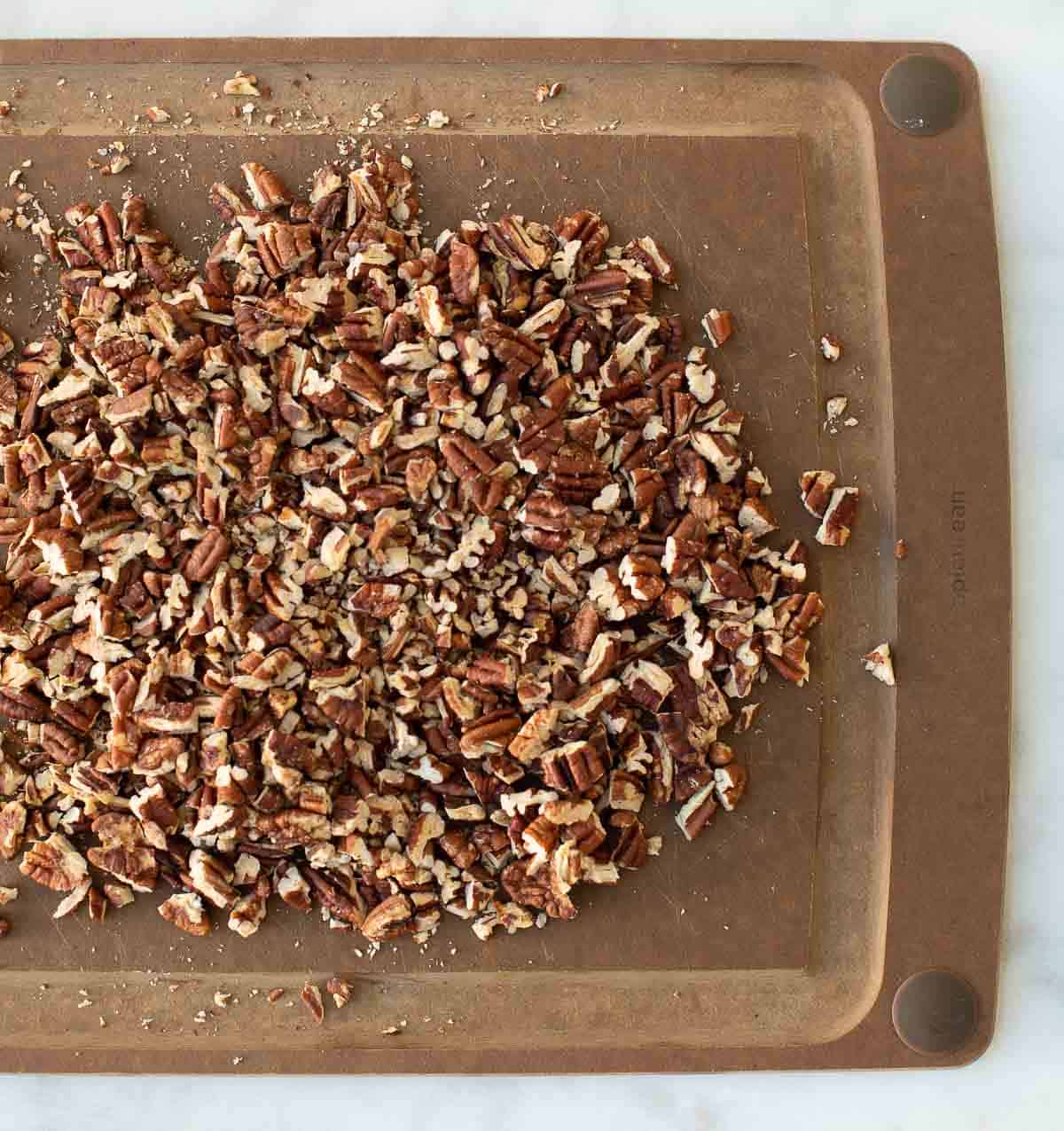 chopped toasted pecans on wood cutting board