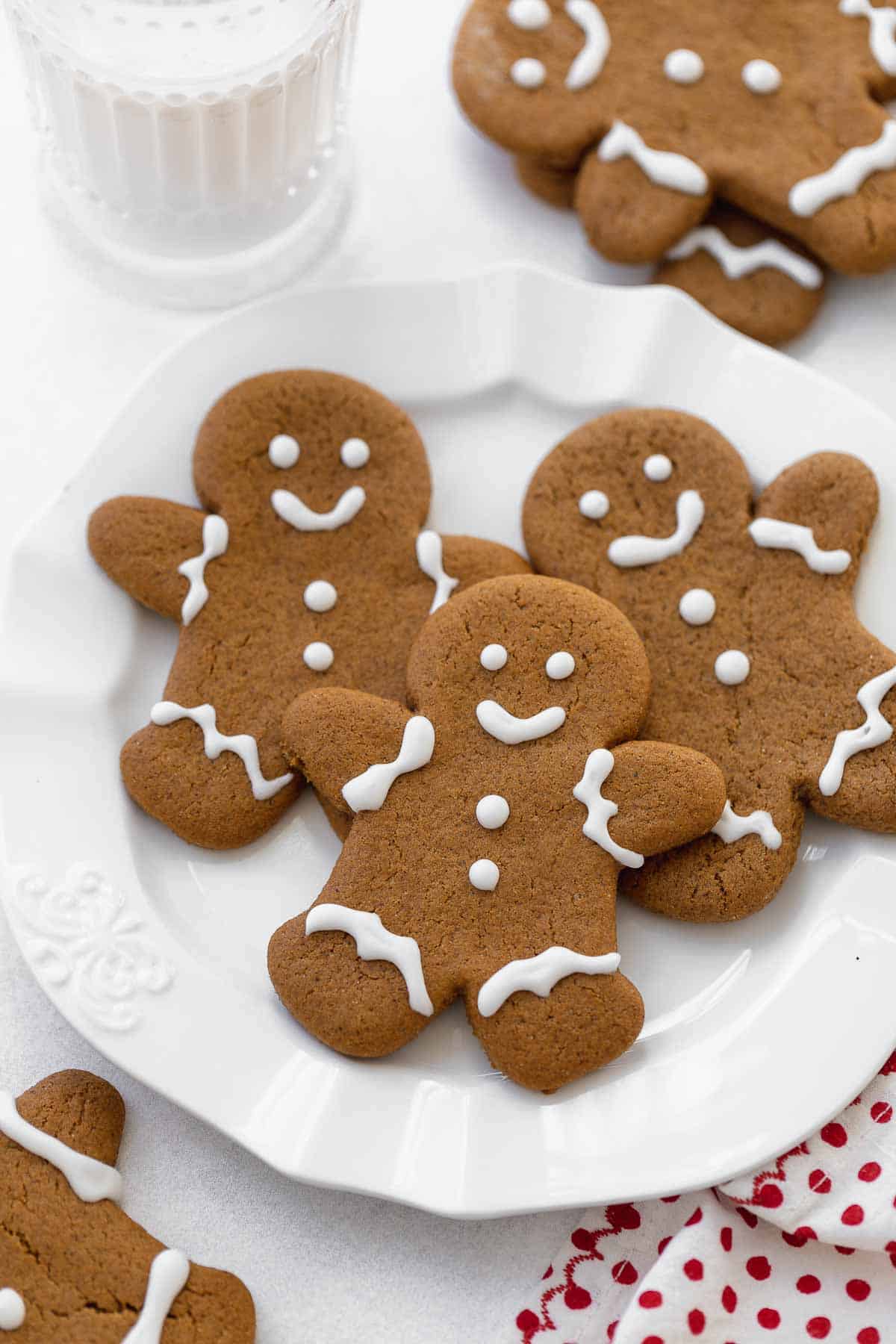 gluten free gingerbread cookies on white plate with glass of milk