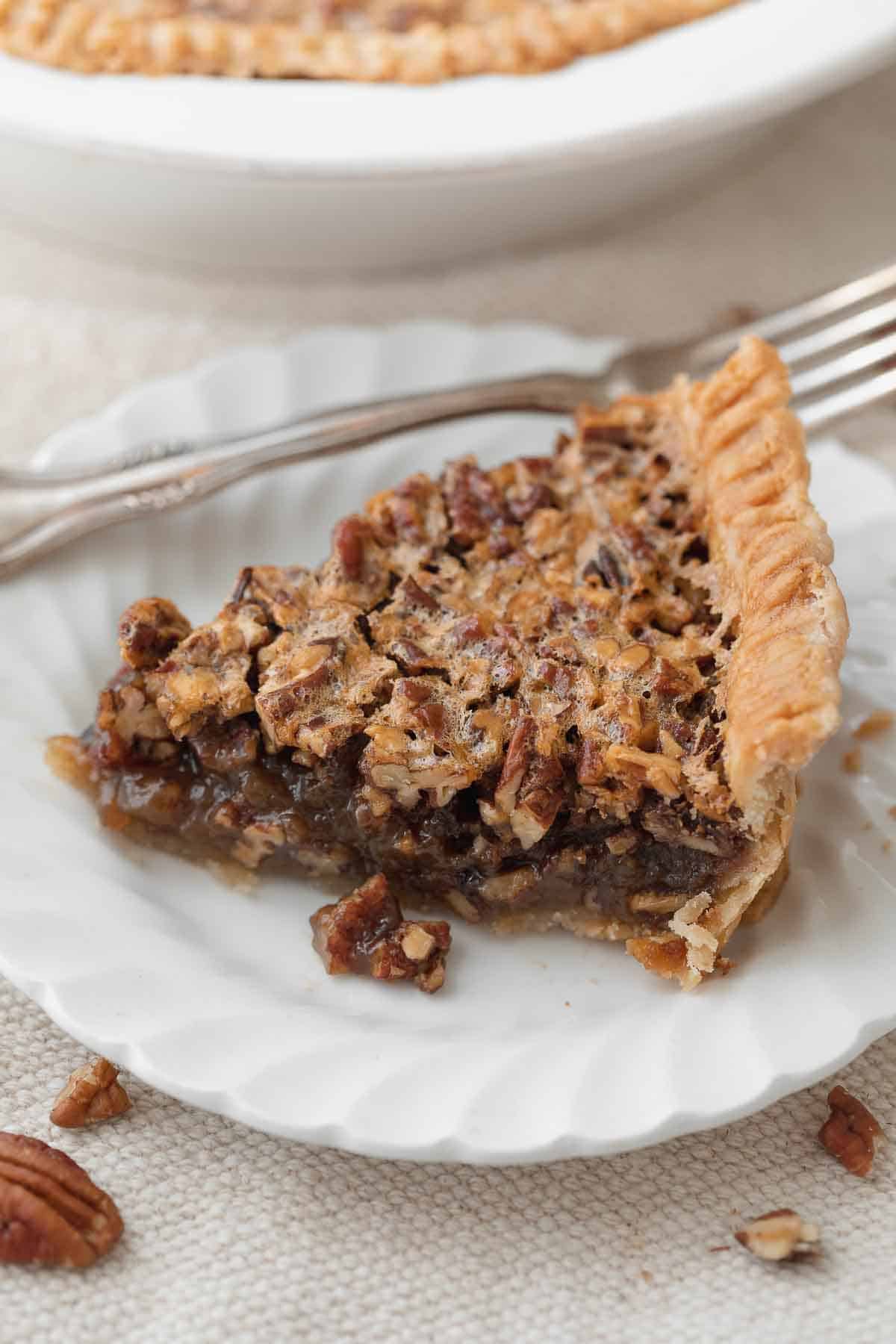 slice of gluten free pecan pie on white plate with fork