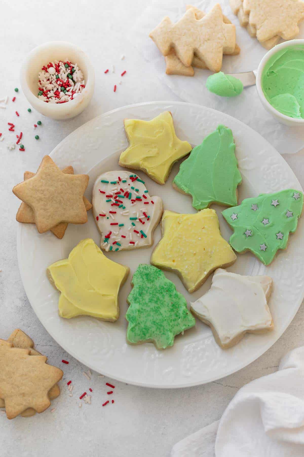 gluten free sugar cookies cut out into christmas shapes on white plate