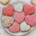 heart shaped sugar cookies frosted with light and dark pink frosting on a white plate