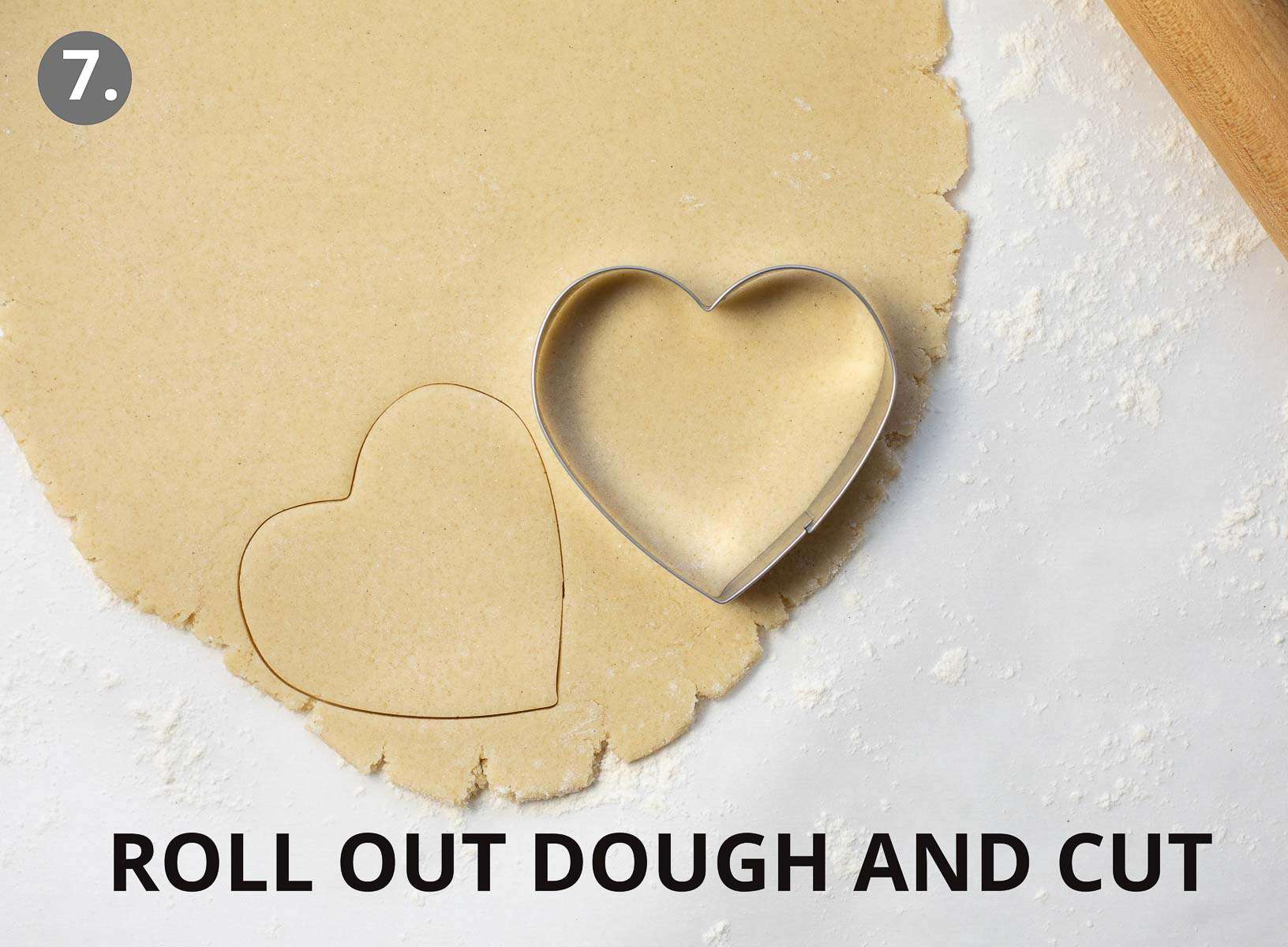 cookie dough rolled out on counter cut with cookie cutters
